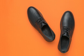 Men's shoes are black on an orange background.