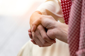 Arab Businessman shaking hands together. Teamwork business partner wear Muslim dress Shake Hands with Partnership Concept. Success UAE diversity people trust make commitment by handshake
