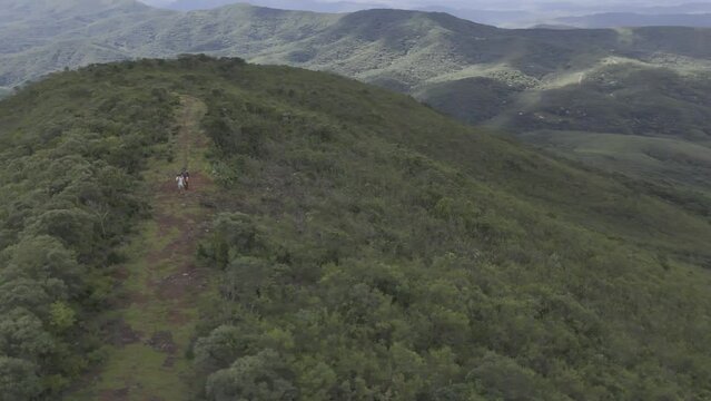Drone orbits in 360 around viewpoint in Parque das Andorinhas as hikers walk through