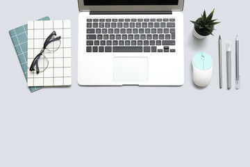 Laptop, computer mouse with eyeglasses and stationery on white background