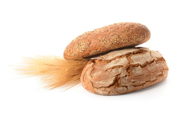 Loaves of fresh bread with wheat spikelets on white background