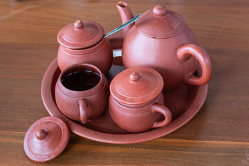 Traditional ceramic teapot and cups on the wooden table