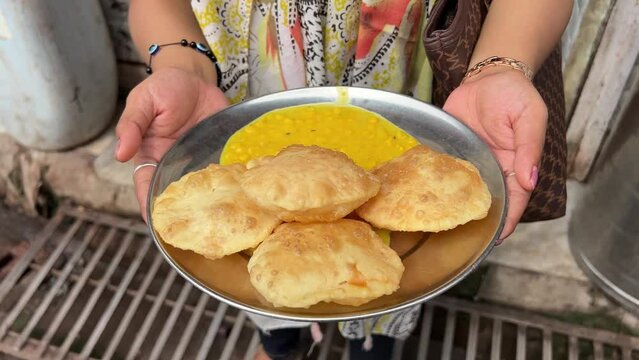 Profile view of luchi and cholar dal served by roadside stall in Kolkata, India.