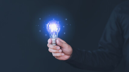 Freelancer hand holding illuminated light bulb. Creative idea, new business plan, motivation, innovation, inspiration. Energy saving light bulb. Concept of new ideas with innovation and creativity. - 784919251