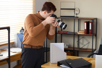 Male spy with photo camera in office
