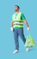 Male volunteer in reflective vest with garbage bag on blue background