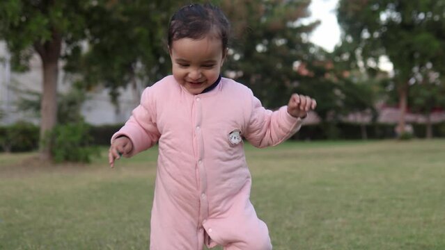 cute indian toddler walking in jumpsuit at outdoor from different angle