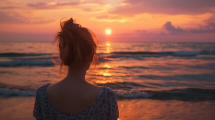 Fototapeta premium Back view of woman on beach at summer sunset