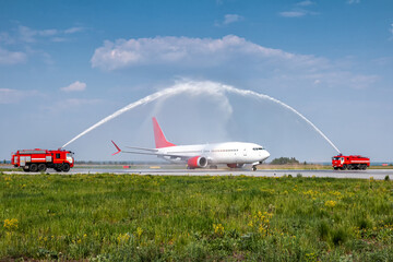 Water arch for first visit white passenger airliner at the airport