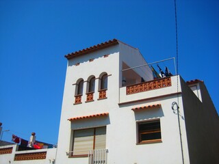 White houses in a classic white town under the blue sky in Girona, Spain