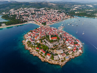 Primosten, Croatia - Aerial view of Primosten peninsula and old town on a sunny summer day in Dalmatia, Croatia with red rooftops and turquoise blue sea water at the Adriatic sea coast
