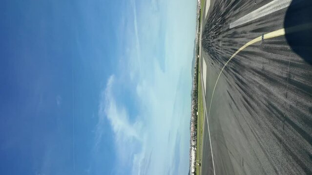 Shadow of a jet airplane leaving the runway after landing. Pilot POV. Vertical shot. Sunny sky with some clouds.