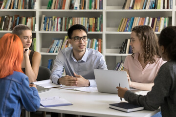 Diverse students share ideas engaged in teamwork working on joint assignment listening opinion or...