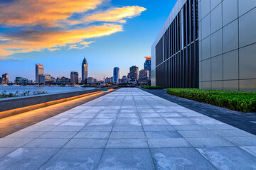 Pedestrian walkway and brick wall with modern city buildings at dusk in Shanghai