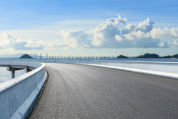 Asphalt highway road and sea with island landscape under blue sky