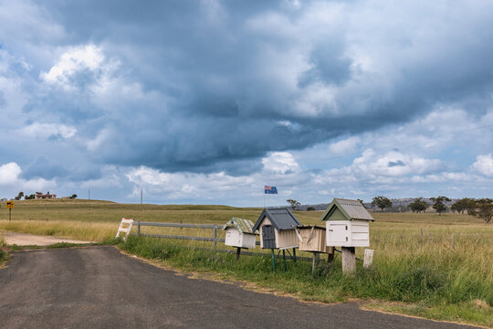Rustic roadside mailboxes in remote area of country New South Wales with Australian flag flying