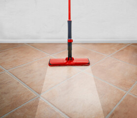 Red Mop on the floor and white wall background