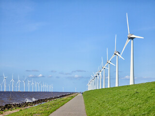 Fototapeta na wymiar offshore windmill park and a blue sky, windmill park in the ocean. Netherlands Europe
