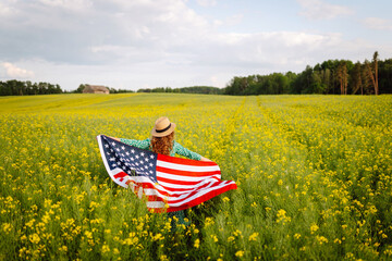 Woman patriot with american flag enjoying sunset at field. 4th of July. Independence Day. 