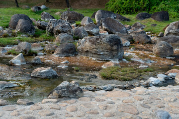 Rocks protruding above the surface of the water in chaeson Hot Spring. with a thin layer of steam....