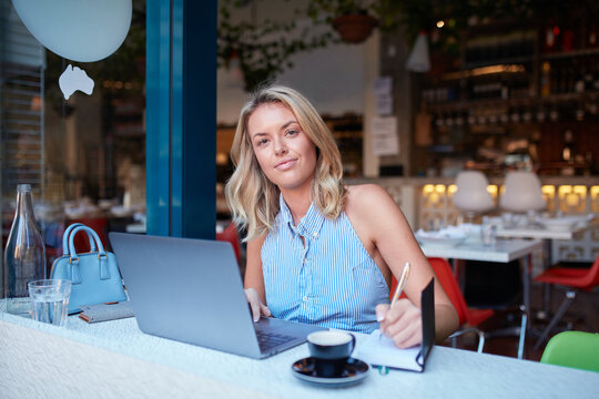 Young woman freelancing from her laptop at cafe
