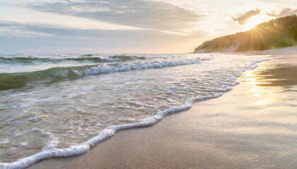 A serene beach at sunset with waves gently lapping the shore and golden sunlight reflecting on the wet sand