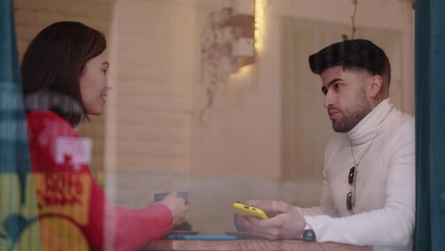 Young male and female in a cafe talking about their lifes. Real people.