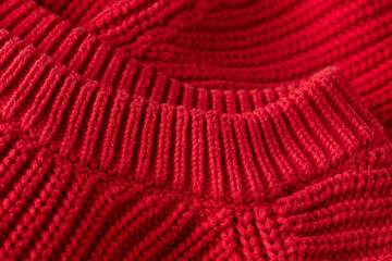 Red knitted texture background, close up of mesh sweater fabric