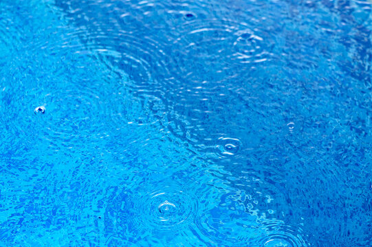 De-focused blurred transparent blue colored clear calm water surface texture with splashes and bubbles.7