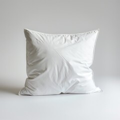 A single white pillow against a neutral grey backdrop, symbolizing comfort and simplicity in interior design.