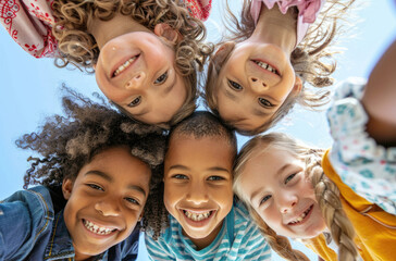 happy multiethnic children huddled together, looking down at the camera, smiling and having fun.