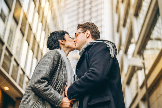 Handsome man and beautiful woman couple falling in love, hugging each other, dancing as they walk around city, having a fun time, lifestyle photo