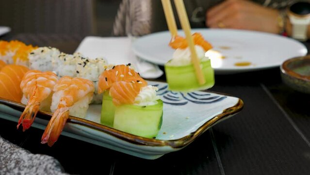 Eating sushi at a restaurant with chopsticks