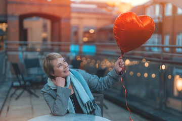 middle-aged happy woman with a heart-shaped balloon falling a love, having a fun day, walking around city Spring is in the air Lifestyle, tourism, valentines day, world woman's day concept