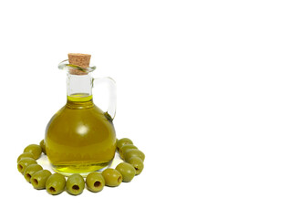Oliwa z oliwek w szklanej karafce, obok zielone oliwki na białym tle z miejscem na tekst - obrazy, fototapety, plakaty