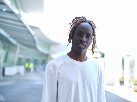 Sudanese man with white t-shirt standing in a courtyard