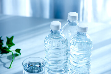 窓際のペットボトルと水の入ったコップ
