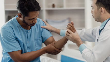 Physical therapist helping a patient while stretching his legs on a bed in a clinic or hospital. Young man attends a physiotherapy course on muscle weakness pain. and heel pain with elastic