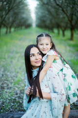 A happy family. Mother and daughter rest in the park in dresses 