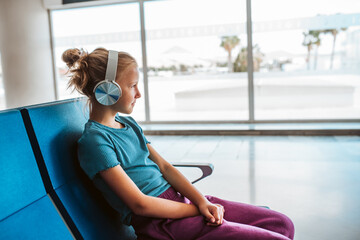 Girl sitting in empty airport of vacation destination, excited about the sea and the beach.