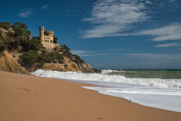 Lloret de Mar Castell on the beach of Sa Caleta, with a strong swell and white waves that reach the...