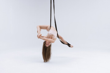 Horizontal photo of a Flexible aerial gymnast performing using gymnast slings. Flying in the air....