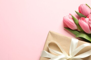 Obraz na płótnie Canvas Happy Mother's Day. Beautiful tulips and gift box on pink background, flat lay. Space for text