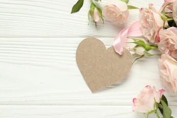 Happy Mother's Day. Beautiful flowers with blank heart shaped card on white wooden table, flat lay. Space for text
