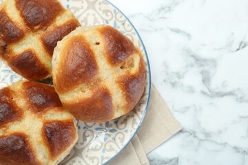 Hot cross buns on white marble table, top view. Space for text