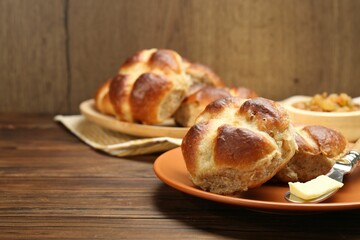 Tasty hot cross buns on wooden table, closeup. Space for text