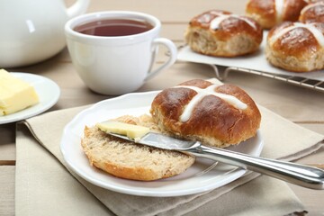 Tasty hot cross bun served on table, closeup