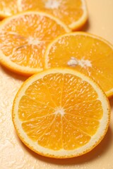 Fototapeta premium Slices of juicy orange and water on beige background, closeup