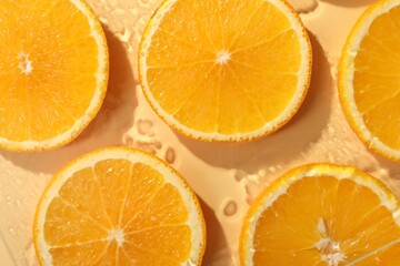 Slices of juicy orange and water on beige background, flat lay