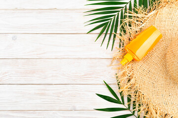 Vacation travel planning simple background of straw hat palm leaves and sunblock lotion on white...
